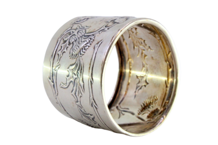 Argola de guardanapo em prata com frutos, ramos e flores relevadas envolvendo cartelapara monograma.